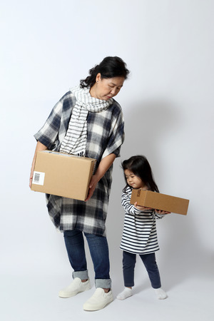 The elder Asian woman holds box with her granddaughter.の写真素材