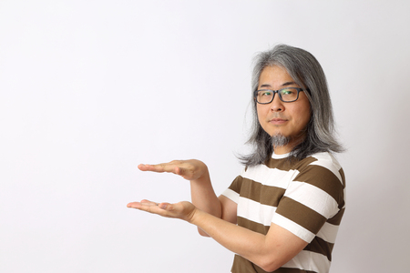 The senior Asian man standing on the white background.の写真素材