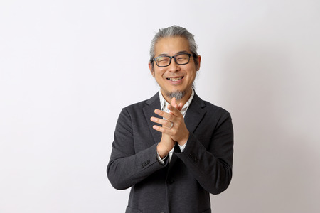The Asian man standing on the white background.