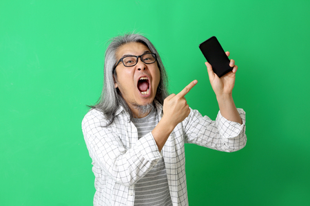 The Asian man on the green background.の写真素材