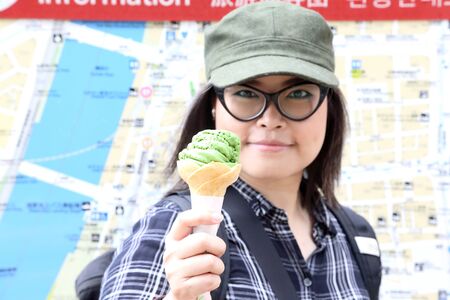 The Asian woman holding ice cream cone.