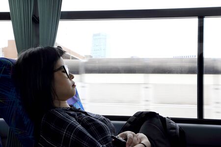 The Asian woman sleeping in the tour bus.の写真素材