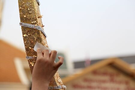 Bangkok, Thailand -February 10, 2013: Thai people helping to apply the golden leaf to the gable apex...