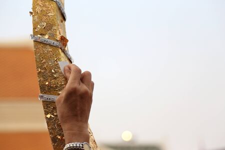 Bangkok, Thailand -February 10, 2013: Thai people helping to apply the golden leaf to the gable apex for the Thai wat building.のeditorial素材