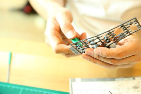 The Asian man doing on plastic model as his hobby.の写真素材