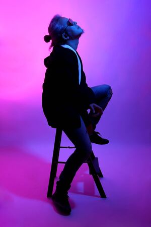 The Asian man posing on the white background with the gel color light.の写真素材