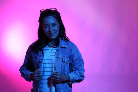 The Asian woman posing in the color gel light.