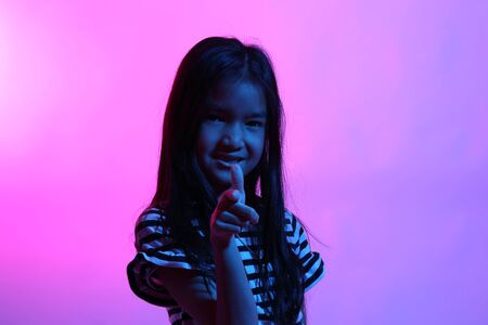 The Asian girl posing in the color gel light.の写真素材