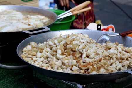 The  stir fried squid eggs in th big hot pan.の写真素材
