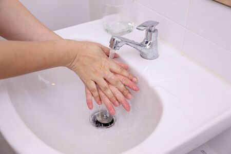 Washing hands in the basin.