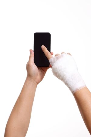 Hands with bandage holding smart-phone.の写真素材