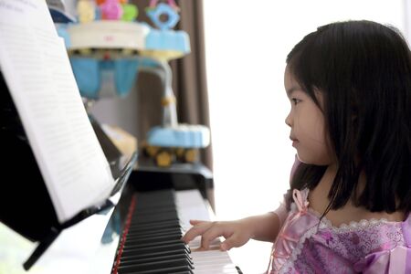 The young Asian kid learning piano.の写真素材