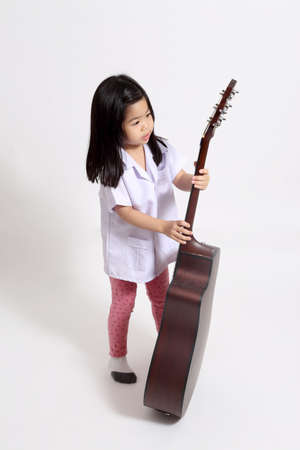 The young Asian girl with acoustic guitar on the whit background.の写真素材