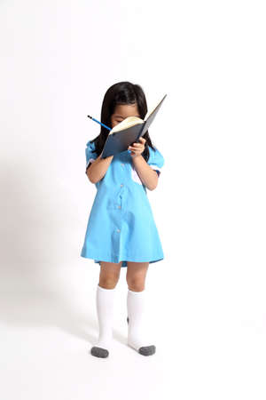 The Asian girl writing in the notebook.
