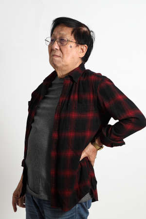 The senior Asin man in in casual clothes on the white background.