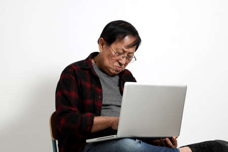 The senior Asin man in in casual clothes on the white background.の写真素材