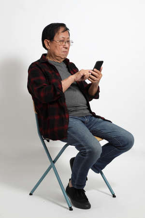 The senior Asin man in in casual clothes on the white background.の写真素材
