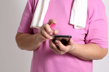 The Asian elder female using alcohol spray to avoid virus.の写真素材