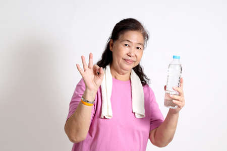 The Asian senior woman in the sport uniform on the white background.の写真素材