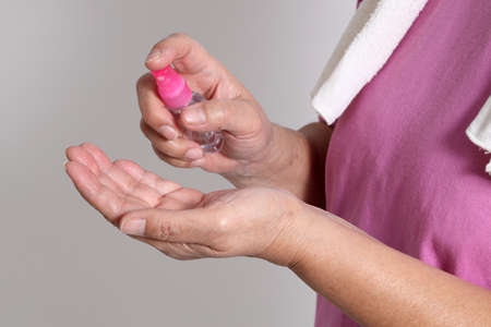 The Asian elder female using alcohol spray to avoid virus.の写真素材