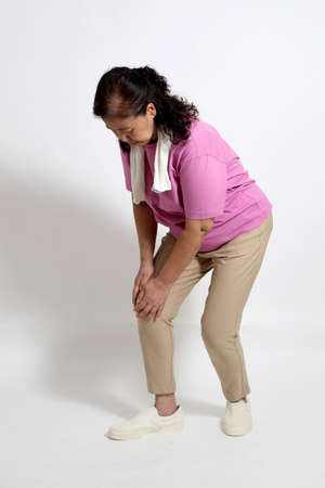 The Asian senior woman in the sport uniform on the white background.の写真素材