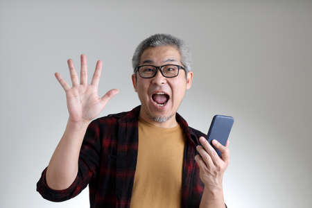 The Asian man standing on the white background.