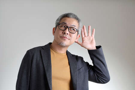 The Asian man in smart casual standing on the white background.