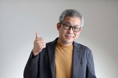 The Asian man in smart casual standing on the white background.の写真素材