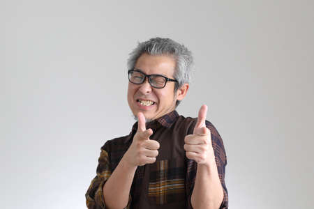 The senior Asian man standing on the white background