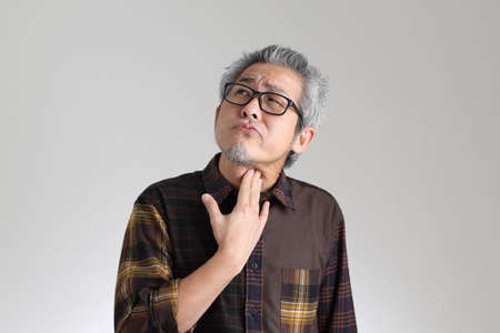 The senior Asian man standing on the white backgroundの写真素材