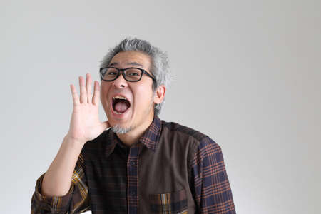 The senior Asian man standing on the white backgroundの写真素材