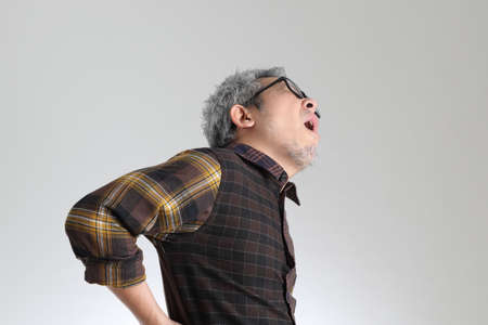The senior Asian man standing on the white background