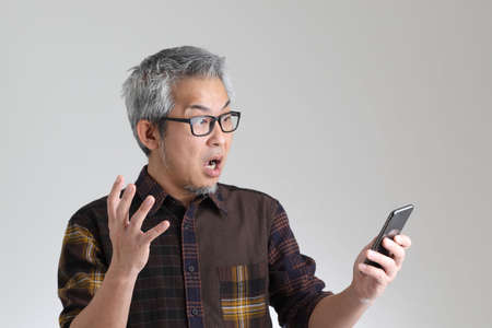 The senior Asian man standing on the white backgroundの写真素材