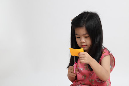 The Asian girl using scissor to cut the paper.の写真素材