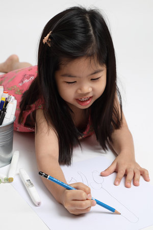 The Asian girl drawing picture on the white background.の写真素材