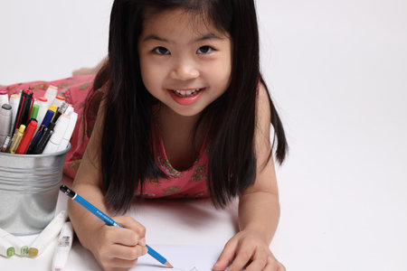 The Asian girl drawing picture on the white background.の写真素材