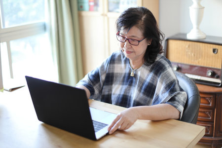 The senior Asian woman using laptop.
