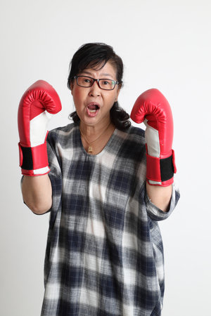 The elder Asian woman standing on the white background.の写真素材