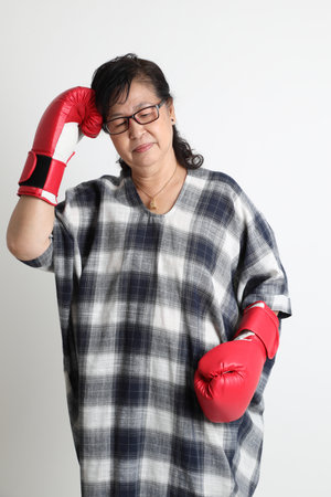 The elder Asian woman standing on the white background.の写真素材