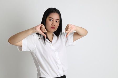 The Asian girl in university uniform standing on the white background.の写真素材