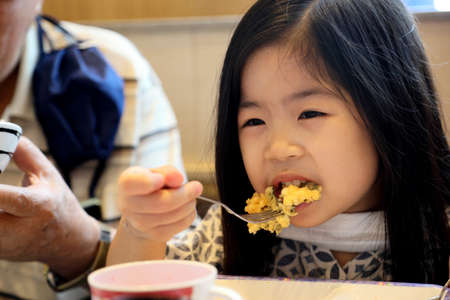 The Asian family having lunch in the restaurant.の写真素材