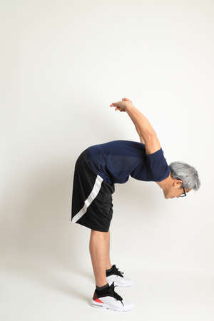 The Asian senior man with sport clothes on the white background.