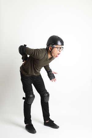 The Asian man with protective gear standing on the white background.