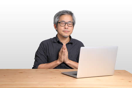 The senior Asian man sitting at the desk.の写真素材