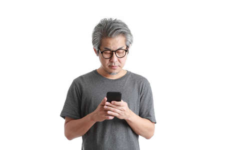 The senior Asian man using smart phone on the whitw background.