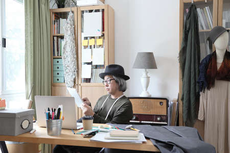 The senior Asian designer working in the studio.の写真素材