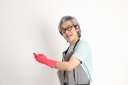 The senior Asian housekeeper standing on the white background.の写真素材