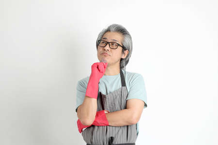 The senior Asian housekeeper standing on the white background.の写真素材