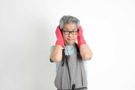 The senior Asian housekeeper standing on the white background.の写真素材