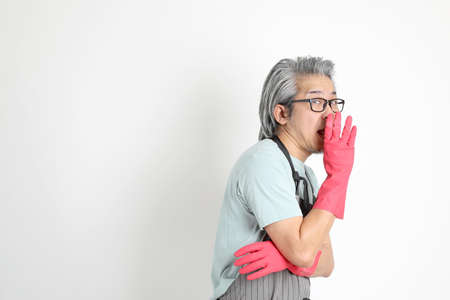 The senior Asian housekeeper standing on the white background.の写真素材
